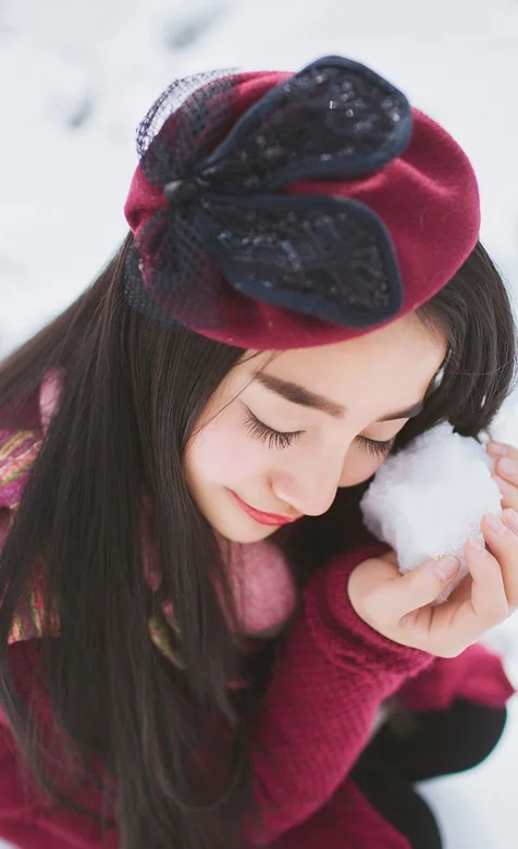 冬季雪地里戴着帽子的美女妹子手机壁纸