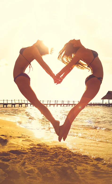 沙滩中组成爱心形状的比基尼美女手机图片