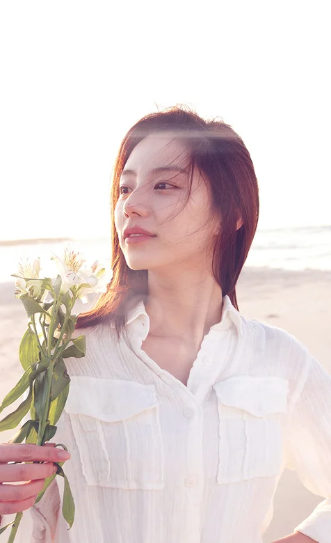 海边拿着花的清纯美女手机桌面