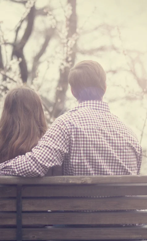 公园椅子上相拥而坐的情侣