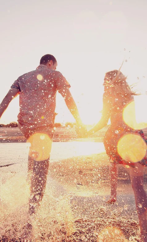 手牵手漫步在沙滩上的欧美情侣