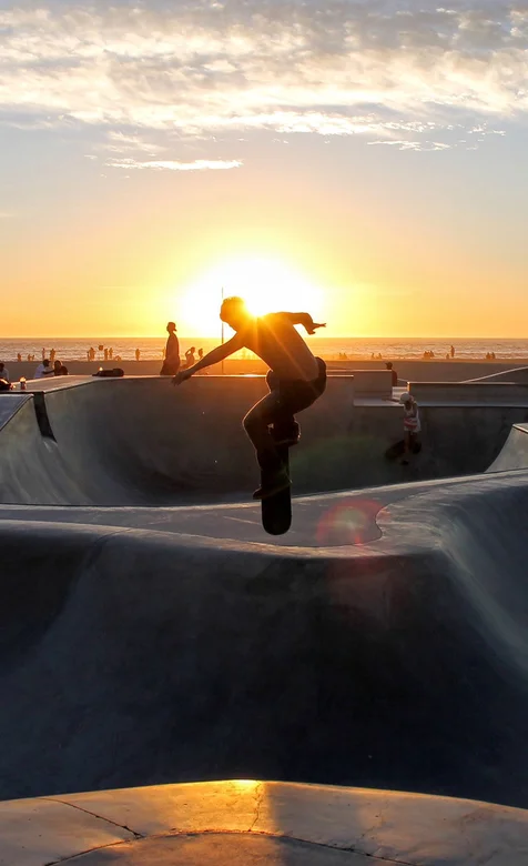 夕阳下的滑板运动爱好者手机壁纸图片