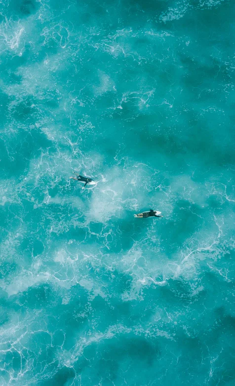 在蔚蓝的海上冲浪的冲浪爱好者航拍