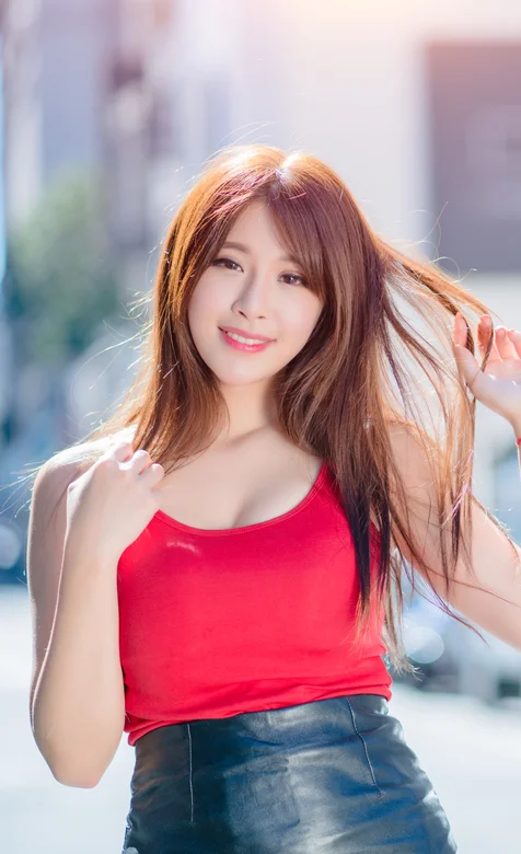 穿红色吊带上衣搭配皮衣短裙的性感大胸美女