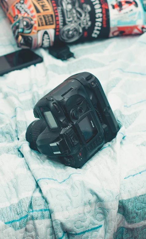床上的尼康专业数码相机手机壁纸