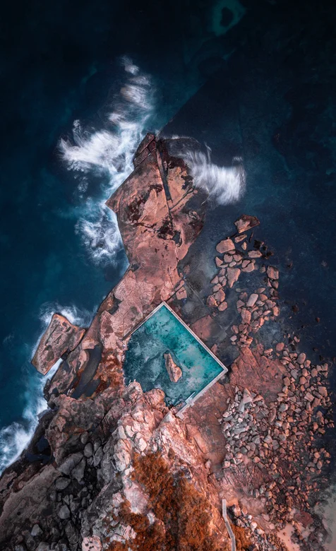 大海礁石边上的泳池航拍唯美风景壁纸