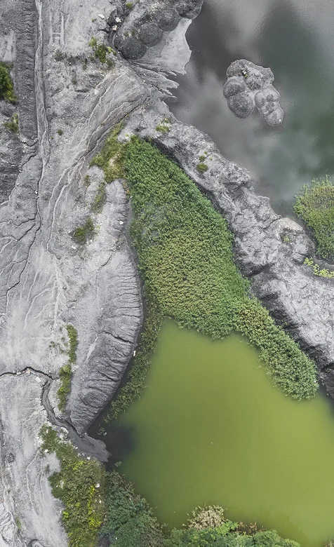 灰色岩体上的一片绿地高空摄影个性手机壁纸