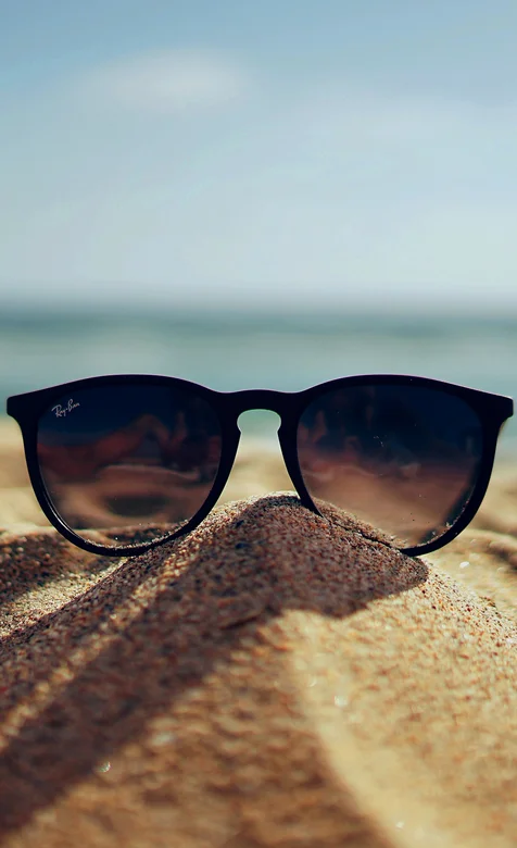 海边沙滩上的墨镜静物摄影高清手机壁纸