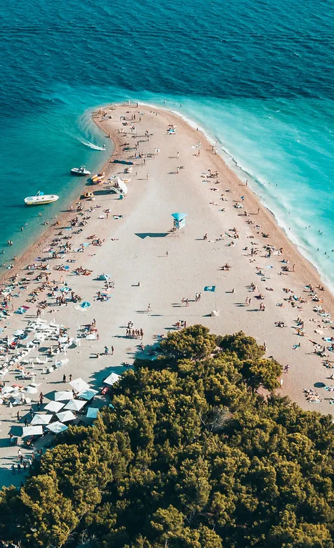 蔚蓝干净海水的U型沙滩和游客们