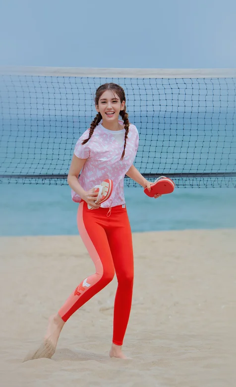 沙滩上穿红色运动裤开心玩沙滩排球的美女高清手机壁纸