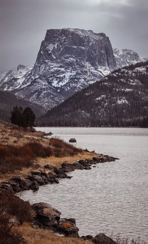 岩壁雪山，山下安静的河流风景手机壁纸