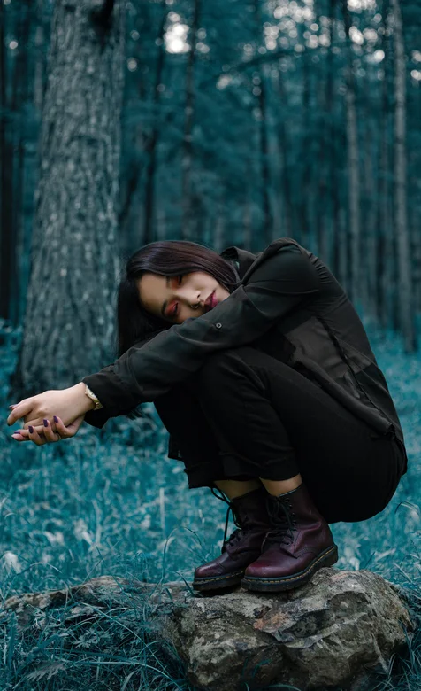 树林里蹲在石头上的长发美女手机壁纸