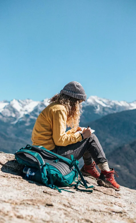 在大山顶写生的欧美美女背包客