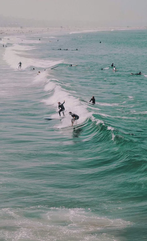 海滨城市沙滩上冲浪的极限运动爱好者