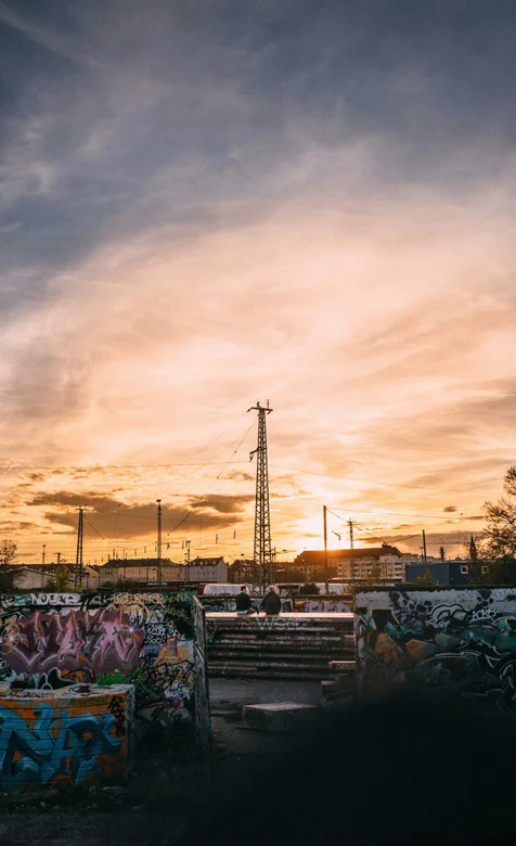 坐在满是涂鸦的墙上看落日的欧美情侣