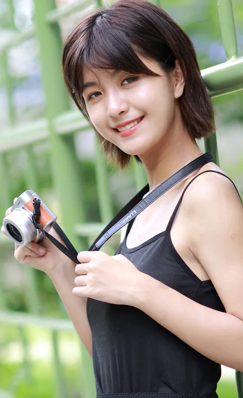 靠着格子栏杆手拿相机穿着吊带上衣的超清纯美女