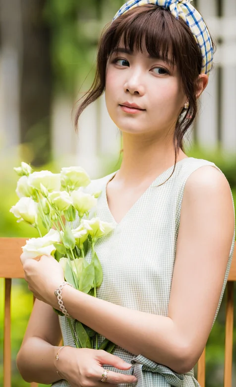 戴花格子发带抱着花的清纯美女
