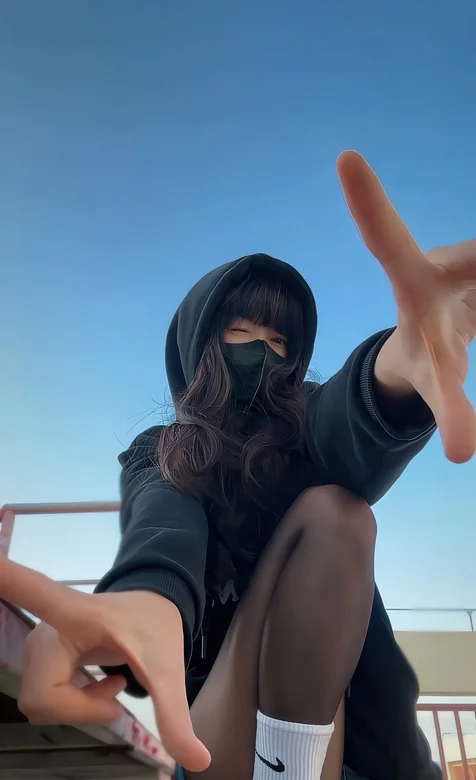 半蹲在地上，身着黑色卫衣，牛仔裤的酷飒女生手势手机壁纸图片