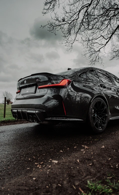 阴天郊外黑色轿车背影图